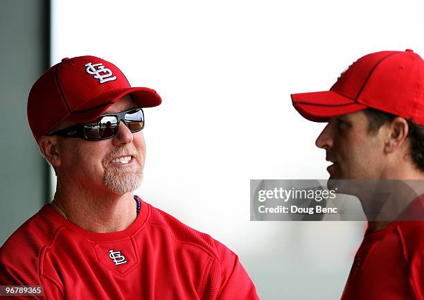 Hitting coach Mark McGwire talks with coach and former teammate Mike Matheny on his first day in uniform during Spring Training on February 17, 2010...