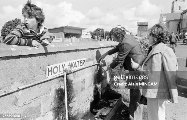 Distribution d'eau bénite à Knock lors du centenaire de l'apparition de la vierge le 21 aout 1979, Irlande.