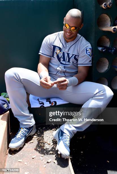 Carlos Gomez of the Tampa Bay Rays looks on from the dugout while eating peanuts prior to the start of his game against the Oakland Athletics at the...