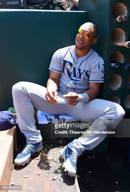 Carlos Gomez of the Tampa Bay Rays looks on from the dugout while eating peanuts prior to the start of his game against the Oakland Athletics at the...