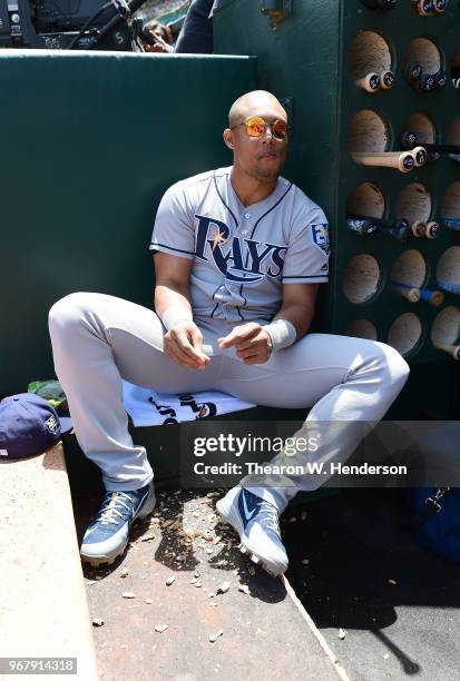 Carlos Gomez of the Tampa Bay Rays looks on from the dugout while eating peanuts prior to the start of his game against the Oakland Athletics at the...