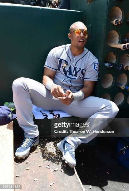 Carlos Gomez of the Tampa Bay Rays looks on from the dugout while eating peanuts prior to the start of his game against the Oakland Athletics at the...