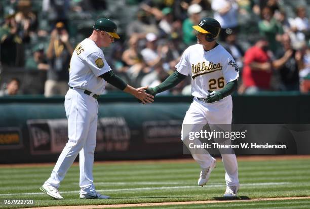 Matt Chapman of the Oakland Athletics is congratulated by third base coach Matt Williams after Olson hit a solo home run against the Tampa Bay Rays...