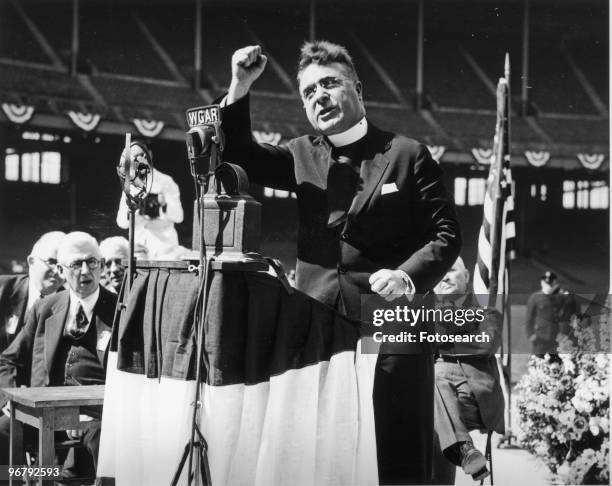 Father Charles Coughlin delivers a radio speech, circa 1930s. .