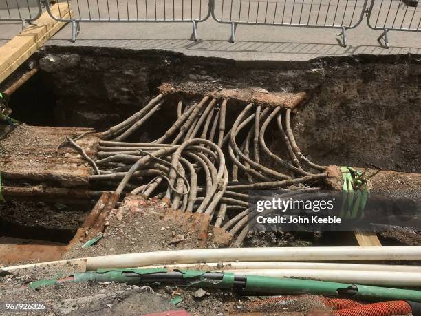 Underground cables and pipes are exposed in a hole during roadworks at the junction of King William Street, Eastcheap and London Bridge on June 2,...