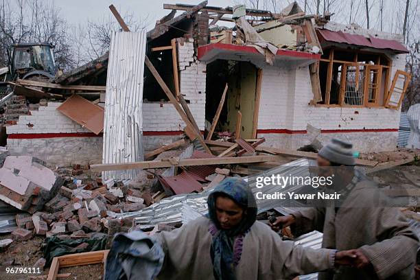 People salvage blongings from their destroyed house where militants were hiding after a gun battle on February 17, 2010 in Kachwa Maqam, 60 km north...