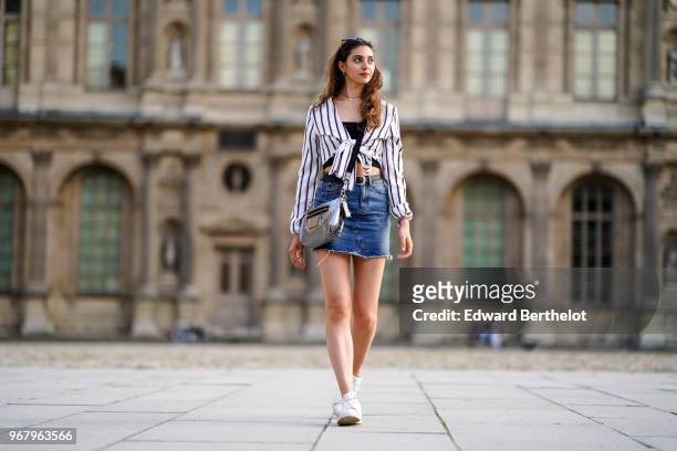 Amanda Derhy wears a Misguided striped top, a Primark blue denim skirt, a Coach silver bag, Adidas Stan Smith white sneakers shoes, on May 27, 2018...