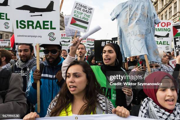 Protesters hold a medical uniform to commemorate the 21-year old paramedic Razan el Najjar who died after being shot by Israeli snipers in Gaza....