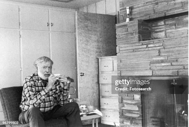 Ernest Hemingway sitting with drink, circa 1960s. .