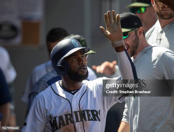 Denard Span of the Seattle Mariners is congratulated by teammates in the dugout after scoring a run during a game against the Texas Rangers at Safeco...