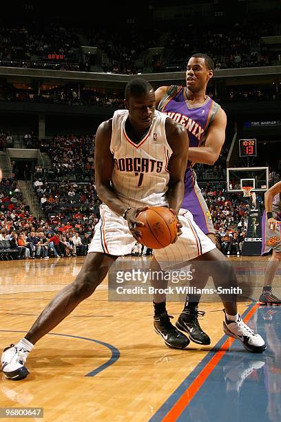 DeSagana Diop of the Charlotte Bobcats moves the ball against Jarron Collins of the Phoenix Suns during the game on January 16, 2010 at the Time...