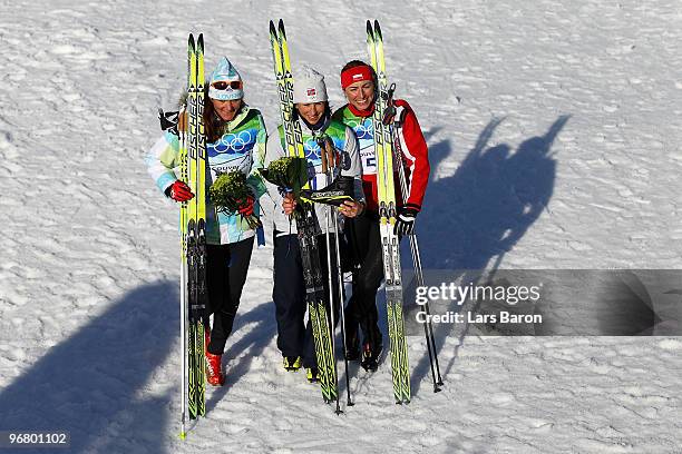 Petra Majdic of Slovenia celebrates winning the bronze medal, Marit Bjoergen of Norway gold and Justyna Kowalczyk of Poland silver during the Women's...