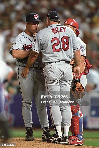 Cleveland Indians pitching coach Mark Wiley meets with pitcher Bartolo Colon as catcher Ivan Rodriguez looks on during the 69th MLB All-Star Game at...