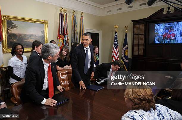 President Barack Obama gets up from his seat after speaking to astronauts on the International Space Station and the Space Shuttle Endeavour February...