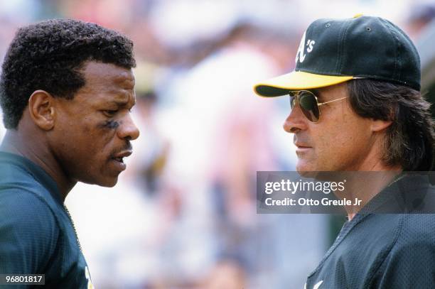 Rickey Henderson of the Oakland Athletics speaks to Manager Tony LaRussa during their MLB spring training game against the California Angels on March...