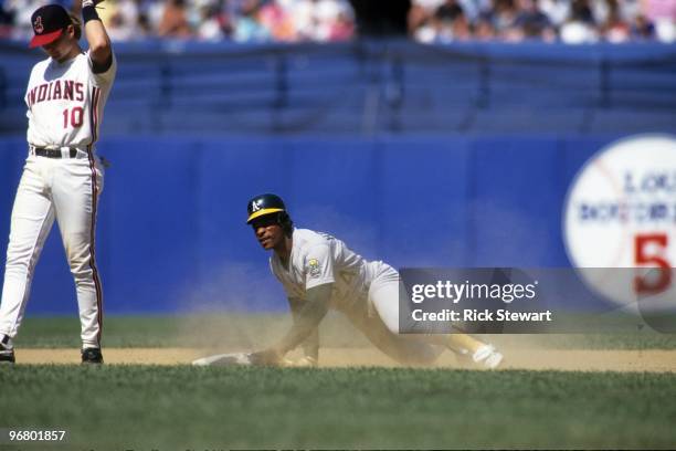 Rickey Henderson of the Oakland Athletics slides to second base during their MLB game against the Cleveland Indians circa May 1991 at Cleveland...