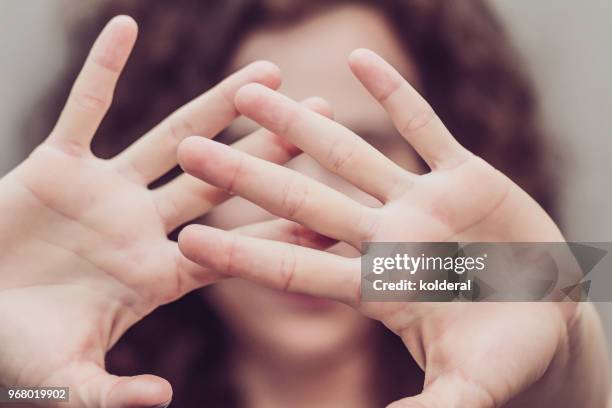woman makes stop gesture with two hands - violence photos et images de collection