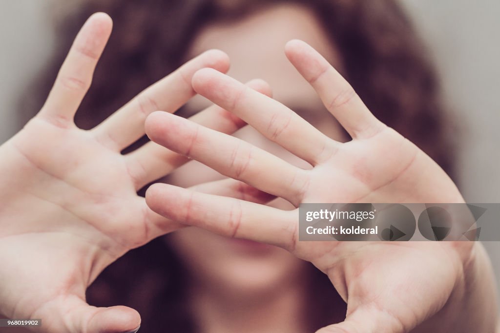 Woman makes stop gesture with two hands