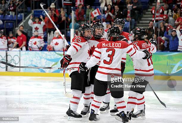 Meghan Agosta of Canada celebrates with teammates after scoring her team's sixth goal during the ice hockey women's preliminary game between Canada...