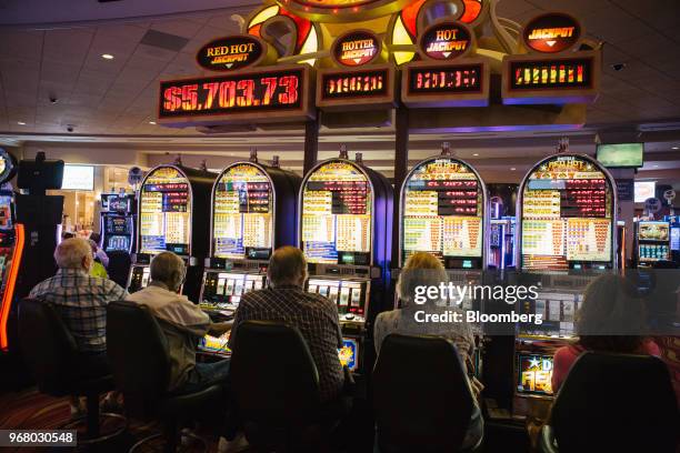 Guests play slot machines on the gaming floor during the launch of full-scale sports betting at Dover Downs Hotel and Casino in Dover, Delaware,...