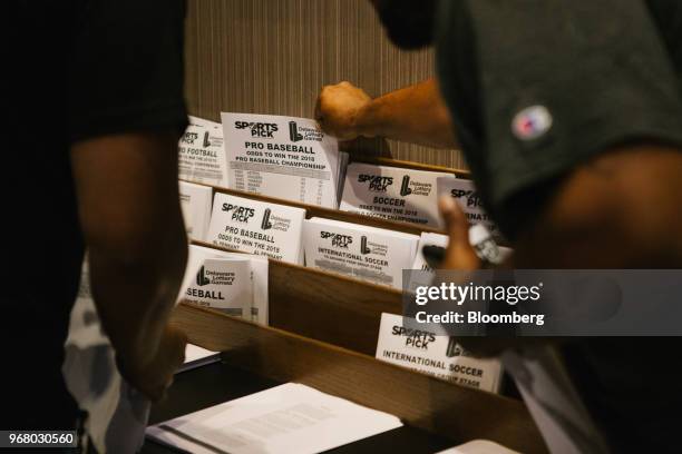 Guests grab pick sheets during the launch of full-scale sports betting at Dover Downs Hotel and Casino in Dover, Delaware, U.S., on Tuesday, June 5,...