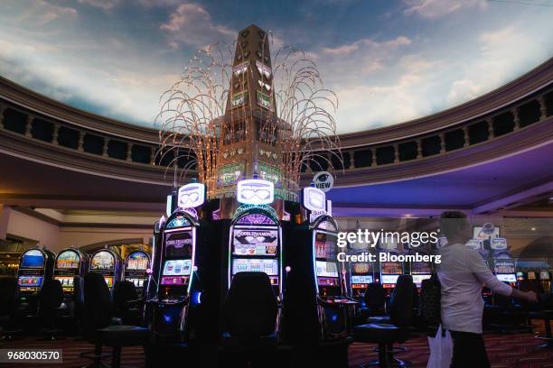 Guest walks past slot machines on the gaming floor during the launch of full-scale sports betting at Dover Downs Hotel and Casino in Dover, Delaware,...