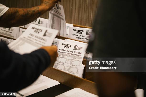 Guests grab pick sheets during the launch of full-scale sports betting at Dover Downs Hotel and Casino in Dover, Delaware, U.S., on Tuesday, June 5,...