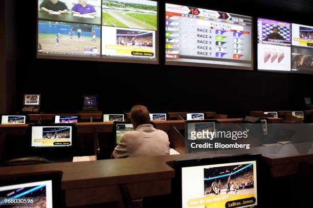 Guest sits in the sportsbook area of during the launch of full-scale sports betting at Dover Downs Hotel and Casino in Dover, Delaware, U.S., on...