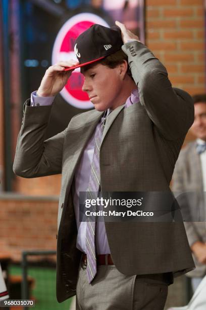 Carter Stewart puts on an Atlanta Braves cap after being selected eighth overall by the Braves during the 2018 Major League Baseball Draft at Studio...