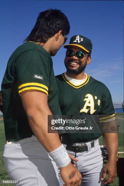 Reggie Jackson and Jose Canseco of the Oakland Athletics speak before a game in the 1987 season.