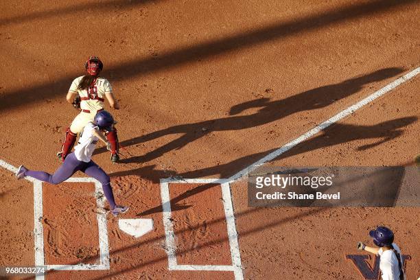 Sis Bates of the Washington Huskies scores against the Florida State Seminoles during the Division I Women's Softball Championship held at USA...