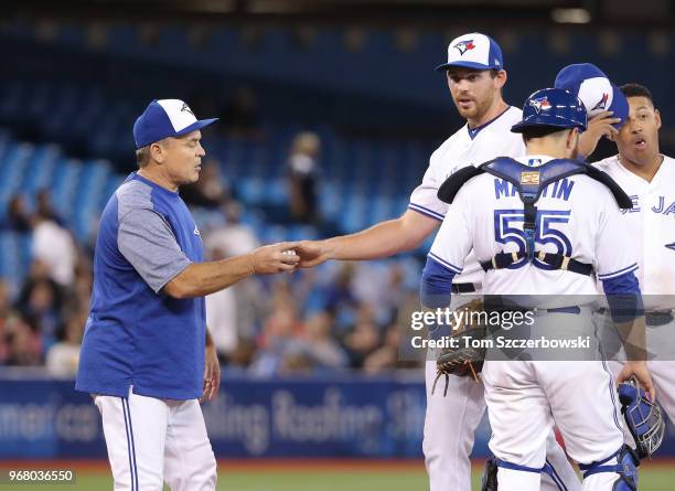 Joe Biagini of the Toronto Blue Jays gives the ball up to manager John Gibbons as he is relieved in the eighth inning during MLB game action against...