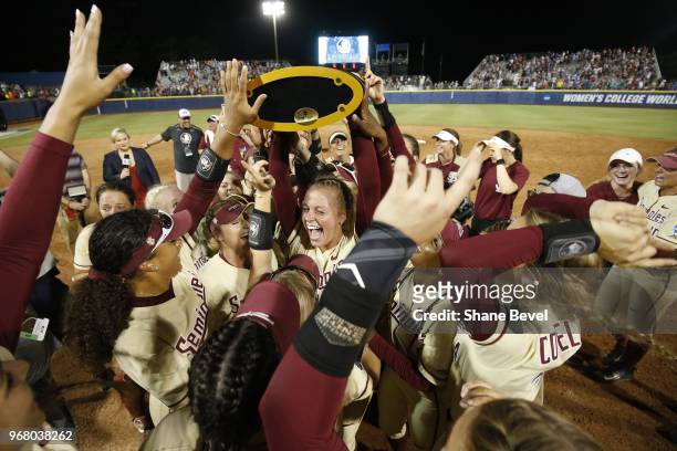 Meghan King of the Florida State Seminoles celebrates with the trophy after defeating the Washington Huskies during the Division I Women's Softball...