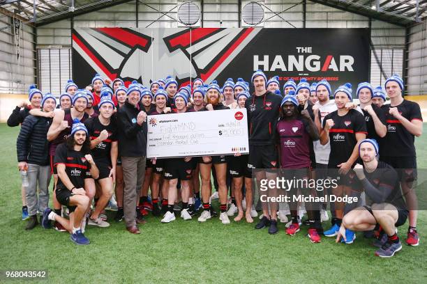 Legend Neale Daniher is presented a cheque by Joe Daniher of the Bombers during an Essendon Bombers AFL media opportunity at The Hangar on June 6,...