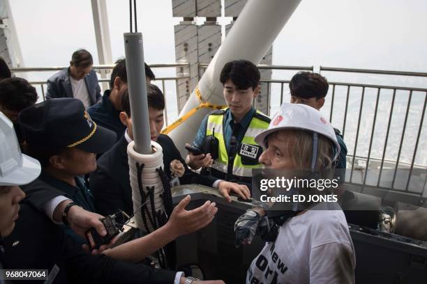 'Urban climber' Alain Robert of France is arrested after being intercepted during his climb of the Lotte World Tower in Seoul on June 6, 2018. -...