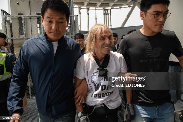 'Urban climber' Alain Robert of France is arrested after being intercepted during his climb of the Lotte World Tower in Seoul on June 6, 2018. -...