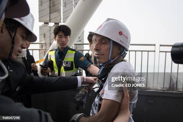 'Urban climber' Alain Robert of France is arrested after being intercepted during his climb of the Lotte World Tower in Seoul on June 6, 2018. -...