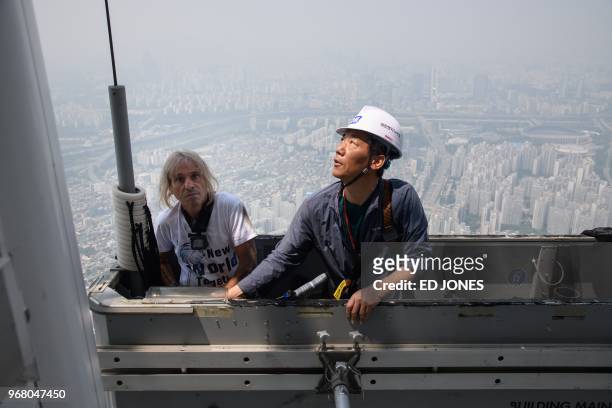 'Urban climber' Alain Robert of France is hoisted to a deck of the Lotte World Tower after scaling the exterior of the building, in Seoul on June 6,...