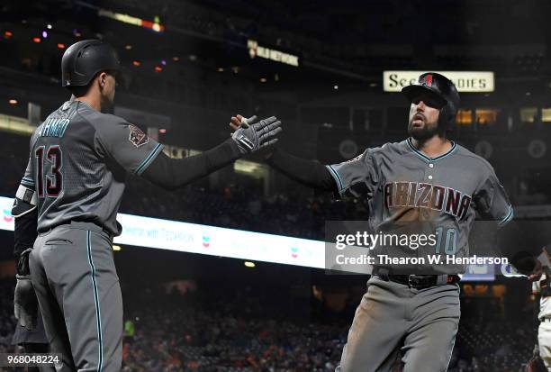 Deven Marrero of the Arizona Diamondbacks is congratulated by Nick Ahmed after Marrero scored against the San Francisco Giants in the top of the...