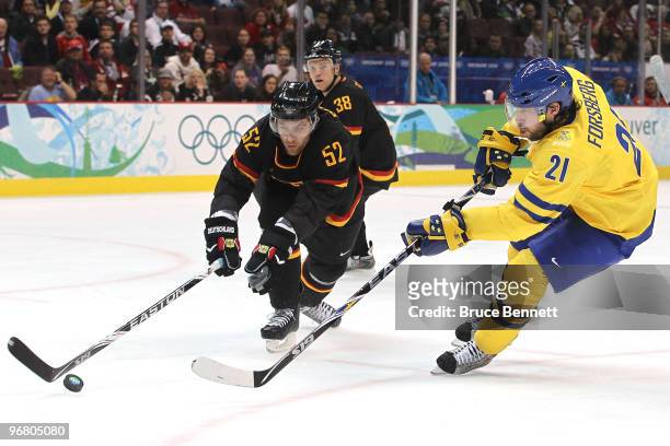 Alexander Sulzer of Germany battles Peter Forsberg of Sweden for the puck in the first period during the ice hockey men's preliminary game on day 6...