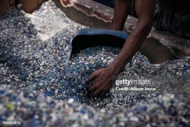 Man works with plastic in a factory along a canal that leads to the Buriganga river on June 3, 2018 in Dhaka, Bangladesh. Bangladesh has been...