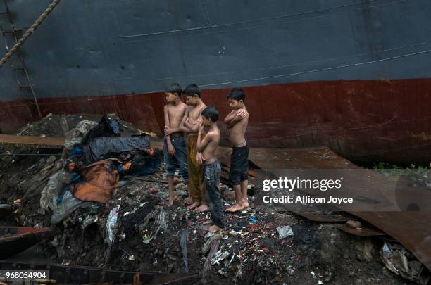 Children stand in the rain in a dockyard on the Buriganga river on June 4, 2018 in Dhaka, Bangladesh. Bangladesh has been reportedly ranked 10th out...