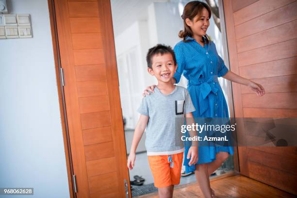 mother and son entering their home - hitting enter stock pictures, royalty-free photos & images