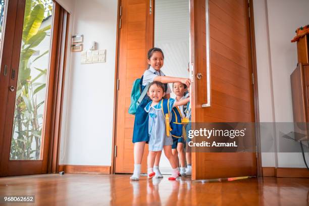 children entering their home - family smiling at front door stock pictures, royalty-free photos & images