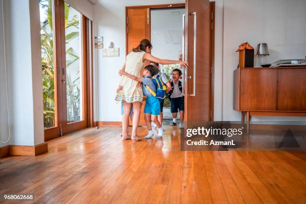 mor omfamnar hennes barn när man kommer hem - man opening door woman bildbanksfoton och bilder