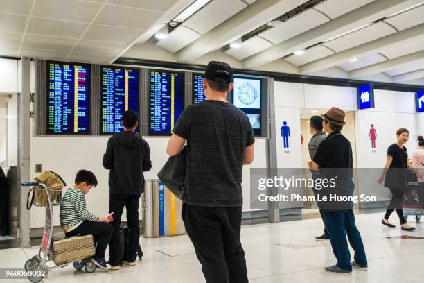 passengres searching for flight at the information board in hong kong international airport - le lounge stockfoto's en -beelden