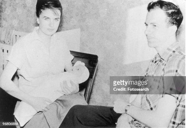 Lee Harvey Oswald sitting with wife Marina Oswald and son June Oswald, circa 1950s. .