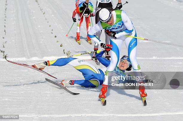 Aino-Kaisa Saarinen of Finland falls next to Slovenia's Petra Majdic as they cross the finish line in the women's Cross-Country Individual Sprint...