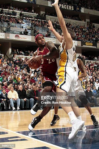 LeBron James of the Cleveland Cavaliers drives to the basket against Josh McRoberts of the Indiana Pacers during the game at Conseco Fieldhouse on...