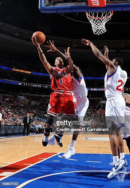 Derrick Rose of the Chicago Bulls shoots a layup against Royal Ivey and Thaddeus Young of the Philadelphia 76ers during the game at Wachovia Center...